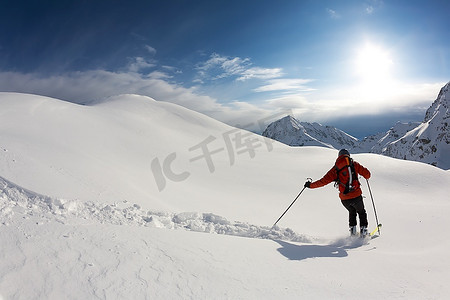 大山摄影照片_自由式滑雪者在雪粉中滑行；意大利阿尔卑斯山。