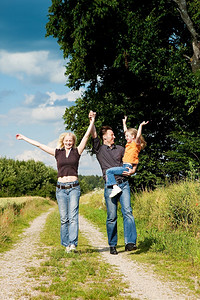 幸福的家庭(母亲、父亲和孩子)在大自然中散步