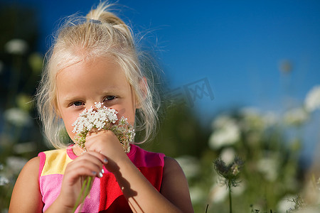 可爱的小女孩闻着花椰草