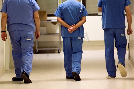 三名医生走在医院走廊上。