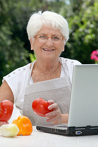 花园里的老年妇女拿着一篮子新鲜蔬菜的特写