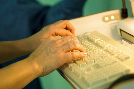手术室外科护士在电脑上打报告.手碑刻