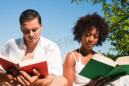 夏天，一对夫妇坐在户外阳光下看书