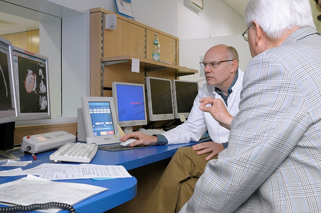 核磁共振摄影照片_放射科医生向老年患者展示心脏核磁共振检查结果