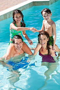 一对父母在假期里和孩子们在游泳池里玩得很开心