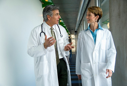 两名医生走在医院走廊上。