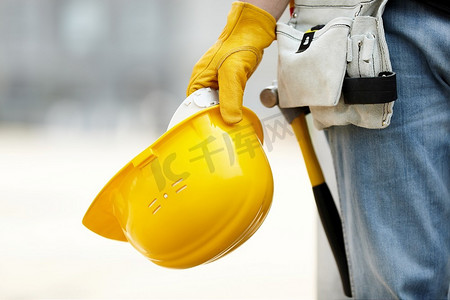 建筑工地上戴着黄色安全帽和工作手套的建筑工人
