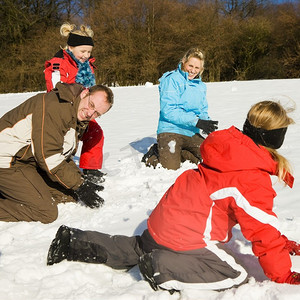 子代摄影照片_冬天，一家人带着孩子在雪地里的山顶上打雪仗