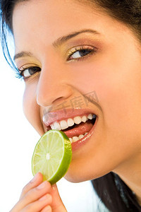 一位年轻漂亮的拉丁女子微笑着舔着一片酸橙