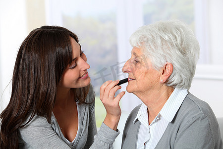老人口红摄影照片_年轻女子帮助老妇人化妆
