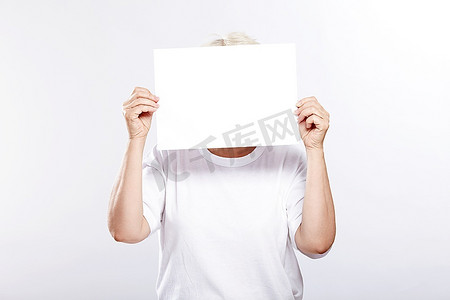 30岁的年纪摄影照片_一位上了年纪的妇女，手里拿着一个白色背景上的人的空盘子
