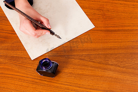 信件钢笔摄影照片_女人(只看到一只手)用钢笔和墨水在纸上写字