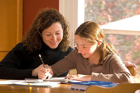 妈妈在帮女儿做家庭作业。