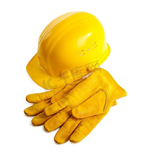 白色背景下隔离的黄色安全帽和工作手套，选择性对焦