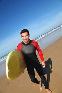 好看黄色摄影照片_带冲浪板的年轻人肖像