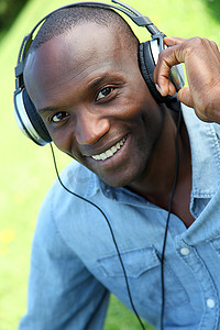 一名男子戴着耳机在花园里放松