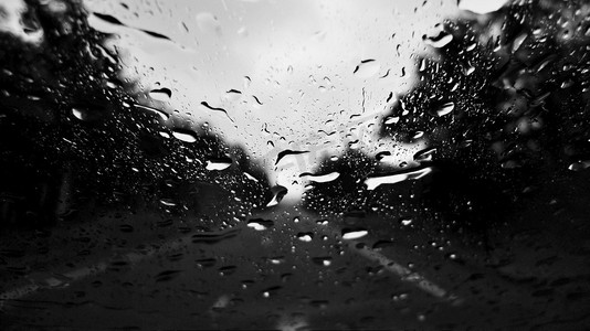雨滴在窗口与模糊的道路在背景中。