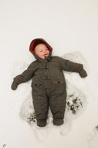 创造生活摄影照片_一个婴儿躺在雪地里，创造了雪地天使