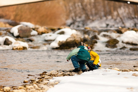 冬天的小男孩们在河岸上玩耍