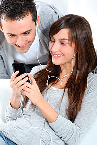 年轻夫妇用手机听音乐