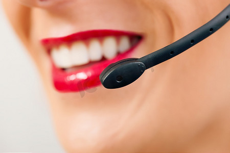 一位友好的女性呼叫中心接线员的肖像(只有部分面部)提供客户服务