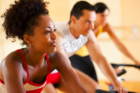 三人一组--想必是朋友--在健身房里旋转，锻炼腿部运动和有氧运动