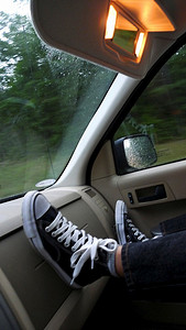 飞驰的汽车摄影照片_男孩和敏锐；S踩在移动的汽车的飞驰上。