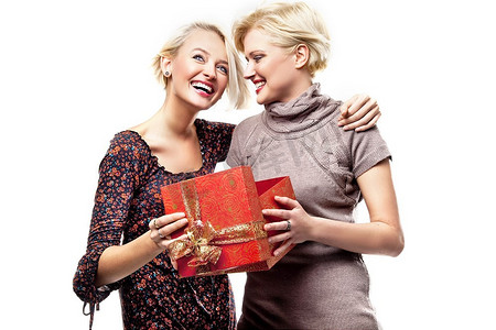 两个微笑的金发美女拿着圣诞礼物