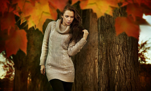 秋天的梦摄影照片_一位怀旧的年轻女子走在秋天的公园里
