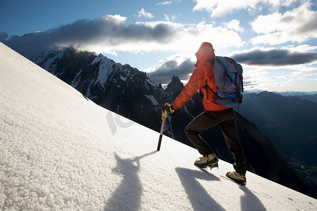 孤独的男性登山者攀登白雪覆盖的山脊；勃朗峰，欧洲。