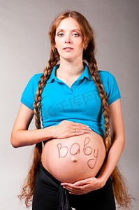 蓝色字幕摄影照片_宝宝在里面孕妇在灰色背景与标题婴儿肚子