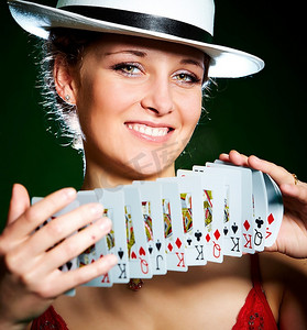 赌徒摄影照片_拿着扑克牌的女孩的照片