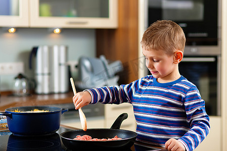 家常菜摄影照片_在厨房里做家常菜？儿子正在照顾他买的肉