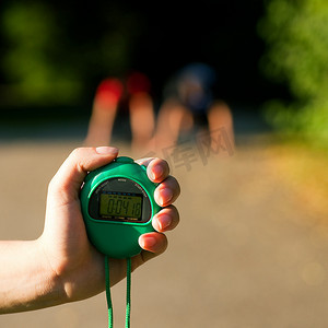 一对年轻夫妇在户外做运动，试图跑步或冲刺，等待开始信号，训练师准备测量他们的表现
