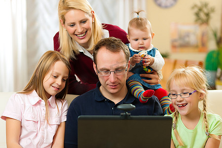 年轻的家庭拿着摄像头在电脑前视频聊天