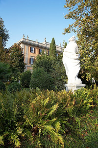 雕像在花园里的新古典主义意大利别墅;科莫湖，意大利。