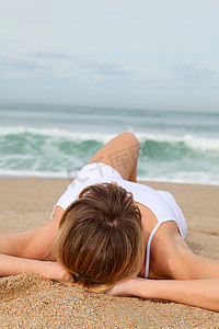 海边女子摄影照片_一名女子躺在海滩上
