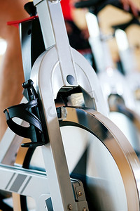 三个人在健身房里旋转，锻炼他们的腿和心脏训练，只看到四肢和轮子