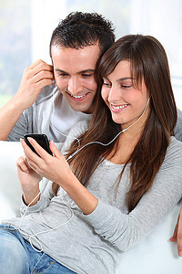 年轻夫妇用手机听音乐