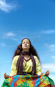 聚焦的摄影照片_蓝天背景下平静的年轻女子，选择性地聚焦在眼睛上