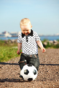 户外运动老外摄影照片_小男孩在户外踢足球
