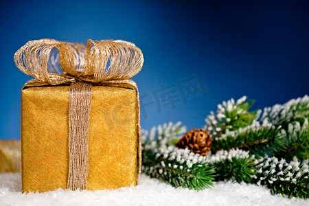 礼品盒和圣诞树树枝在蓝色的背景上雪地。寒假概念