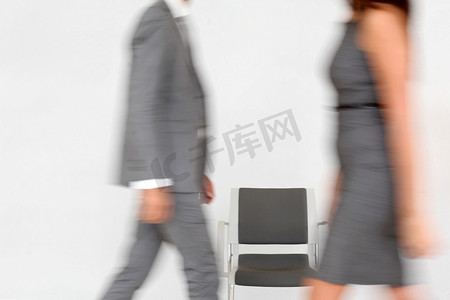 商务人士坐在走廊里的椅子上行走