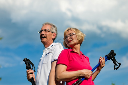 北欧漫步-快乐的成熟或老年夫妇在夏季进行户外运动
