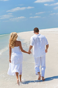 幸福的年轻情侣牵着手在热带海滩跑步或散步