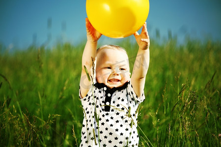 可爱黄人摄影照片_年轻的微笑男孩打黄球