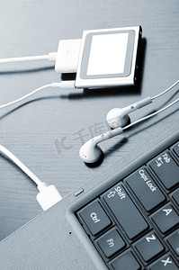 配备现代触摸屏音乐播放器的笔记本电脑，蓝色色调，俯瞰，专注于播放器