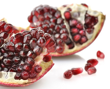 成熟的石榴与红色种子在白色背景,特写