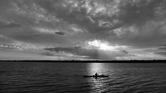 日落时分，风景秀丽的湖面上勾勒出独木舟的身影。