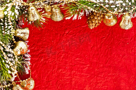 红纸背景上的树枝和铃铛的圣诞相框